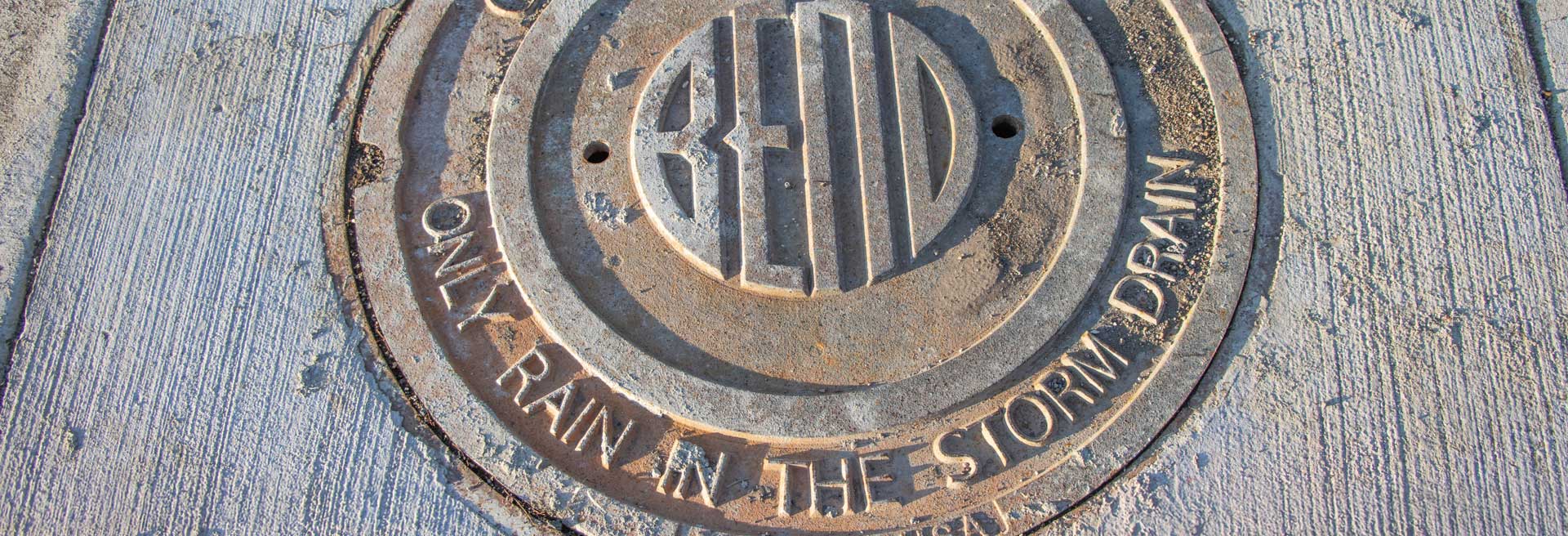 Maintenance hole cover with City of Bend logo on it.