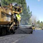Machine paving a street.