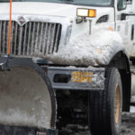 Snowplow plowing a city street.
