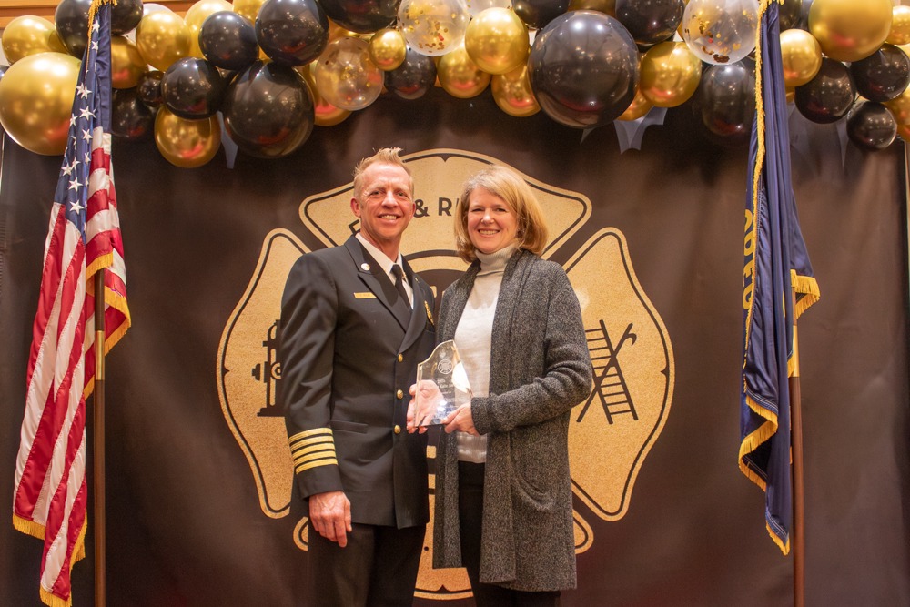 Robin receives the Klondike Kate Award, presented by Bend Fire & Rescue Chief Riley.