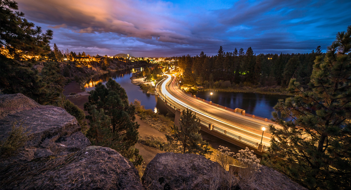 City Street at night that runs next to a river.