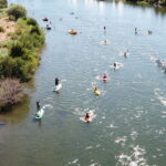 Paddleboarders and others on a river from above
