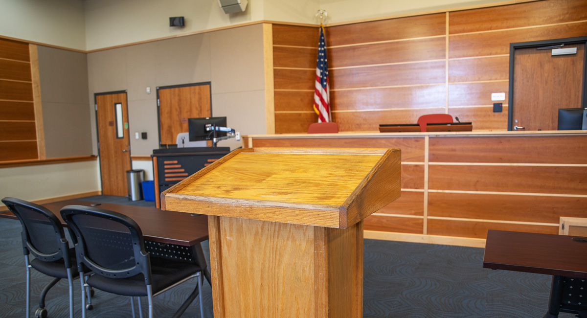 Inside of a court room with a diesis and a podium in front of the diesis.