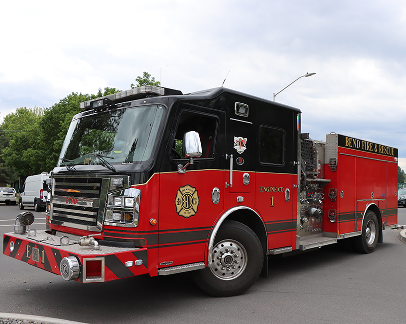 Red fire engine sitting on a street.