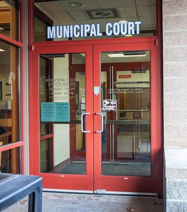 Glass doors going into the court building. Municipal Court lettering is installed above the door.