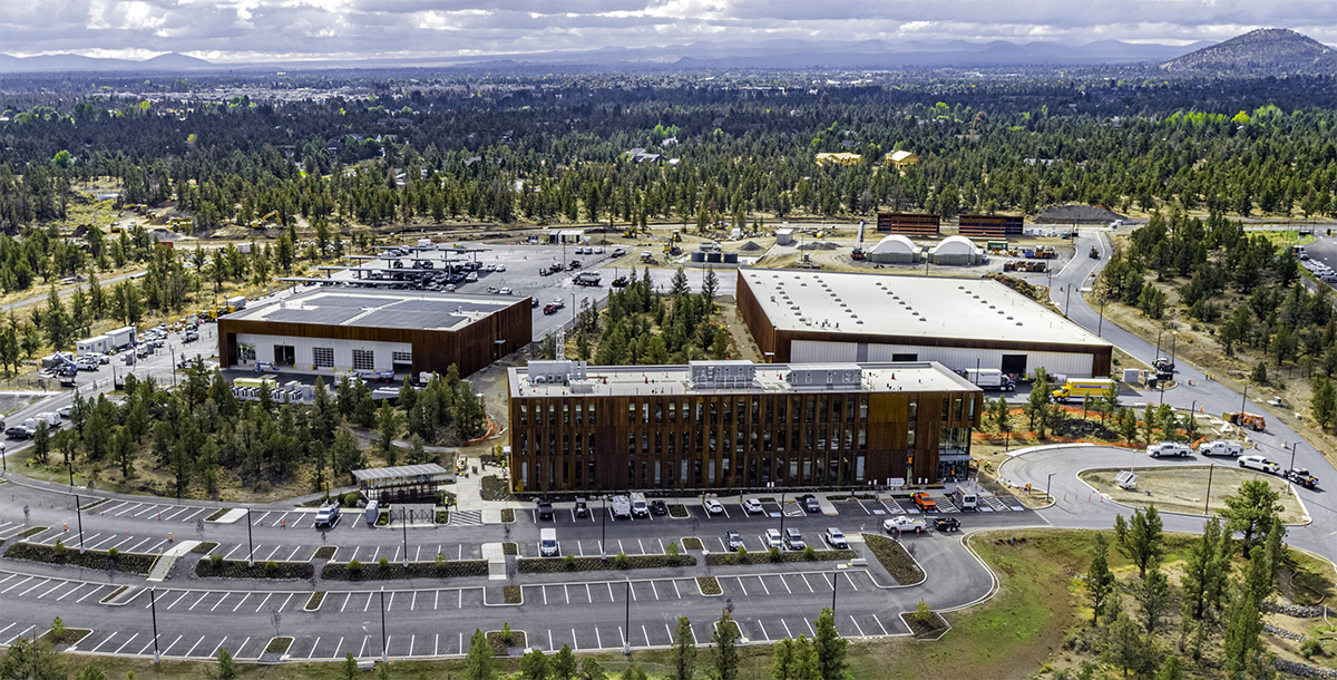 Overhead shot of the campus with 3 large buildings and parking lots.