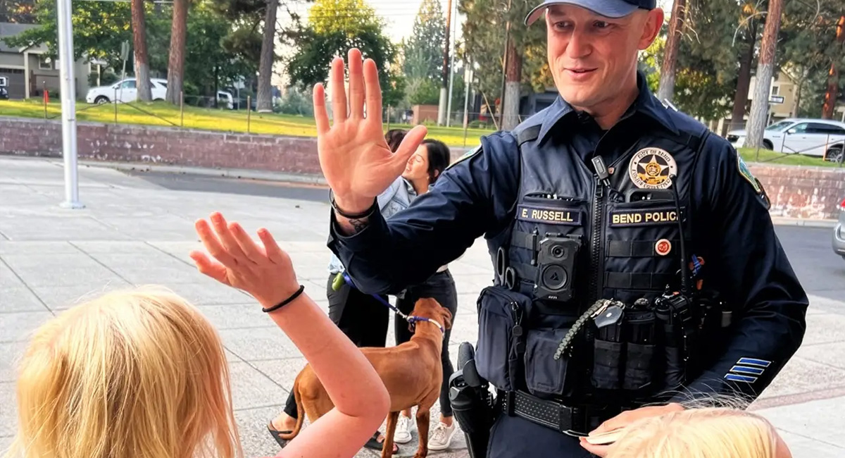 Police officer giving a high-five to a child.