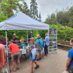 People visiting a booth on Water Conservation in a park.