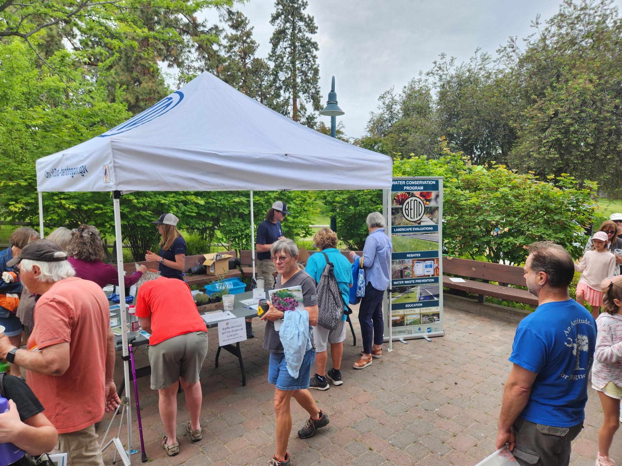 People visiting a booth on Water Conservation in a park.