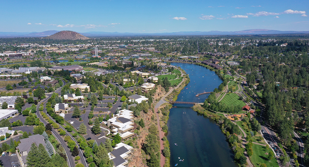 Imágenes aéreas de un río rodeado de parques, calles y edificios.
