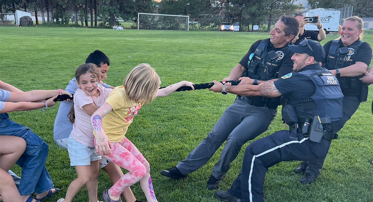 Police officers playing a game of tug-o-war with children.