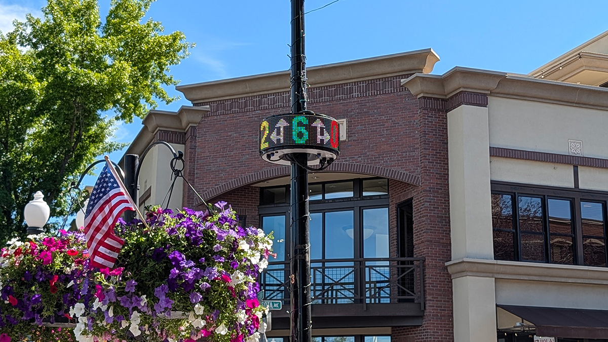 Sign on a light pole indicating available parking spaces nearby.
