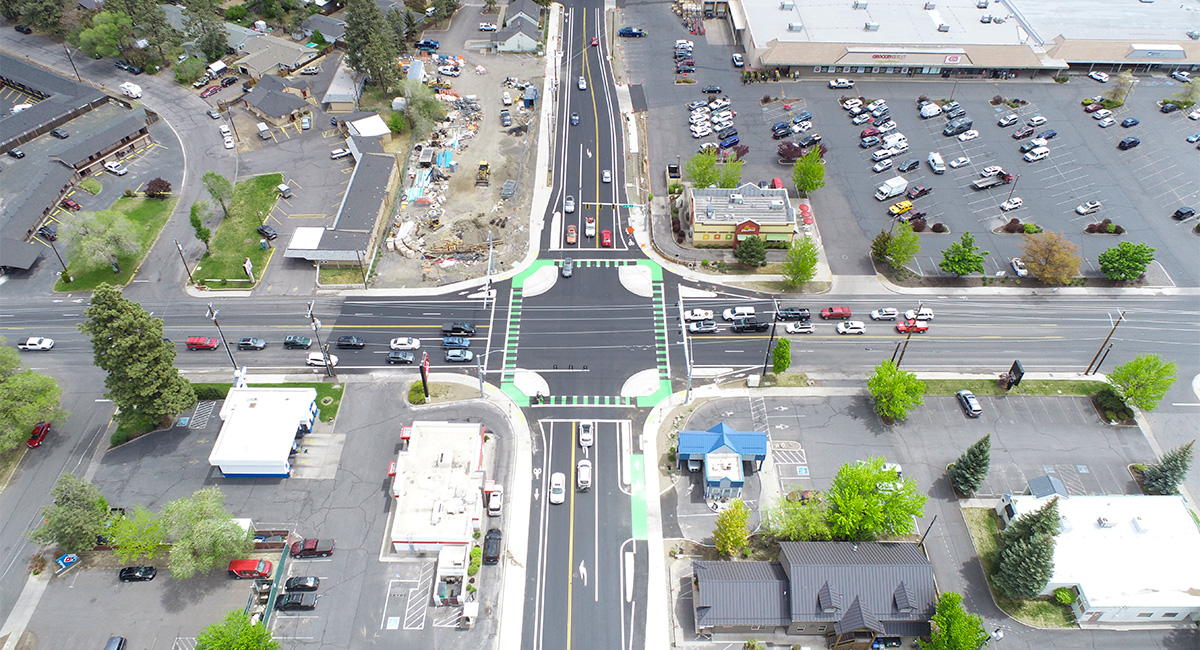 Overhead view of a protected intersection. Cars are at the intersection at stop lights.