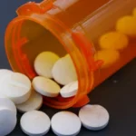 Pill bottle with pills inside and out.